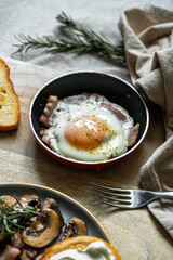 Breakfast with fried egg(sunny side up) with bacon, grilled with rosemary mushrooms and toast with cream cheese