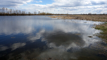 The clouds are reflected in the lake. Spring Siberian landscape. 