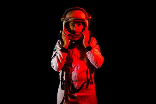 Astronaut in space suit standing in red neon light