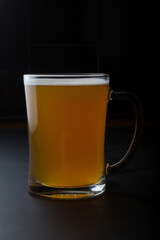 Glass of lager beer served on a black