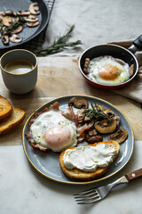 Breakfast with fried egg(sunny side up) with bacon, grilled with rosemary mushrooms and toast with cream cheese