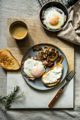 Breakfast with fried egg(sunny side up) with bacon, grilled with rosemary mushrooms and toast with cream cheese