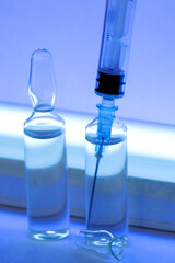 Syringe and ampoules close up. Medicines for injection and a germicidal lamp.