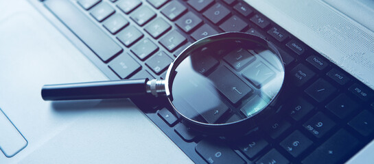 Internet search concept, magnifier on computer keyboard