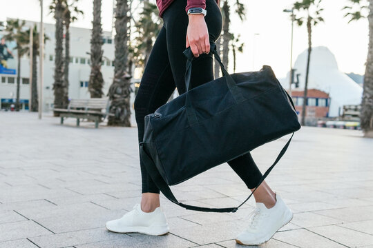 Sporty woman with bag walking on street