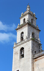 Fototapeta na wymiar Tower of the Cathedral of San Ildefonso on the main square Plaza Grande in Merida, Yucatan, Mexico. It is first cathedral finished on the American mainland and the only one built during 16th century