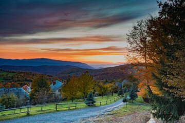 Beautiful autumn mountains landscape, village at the sunset © oksix