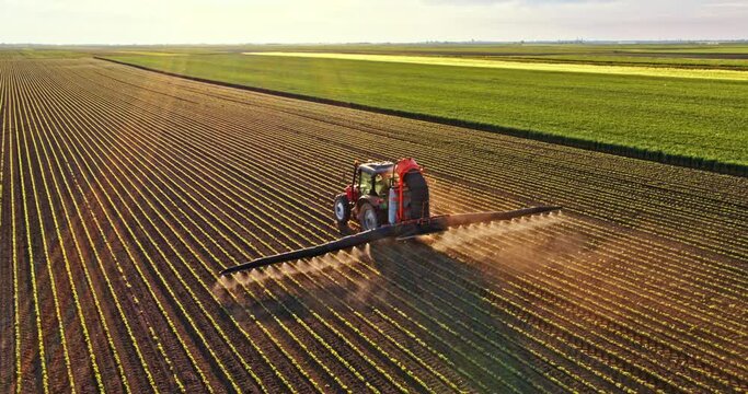 Tractor spraying pesticides on agricultural field