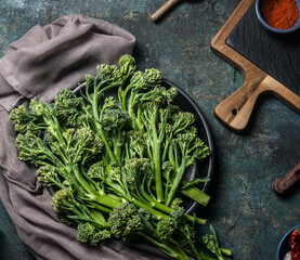 Bunch of wild broccoli on a dark kitchen table for healthy cooking and vegan cuisine. View from...