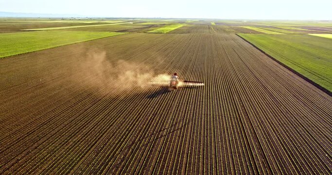 Farmer on tractor spraying soybean field