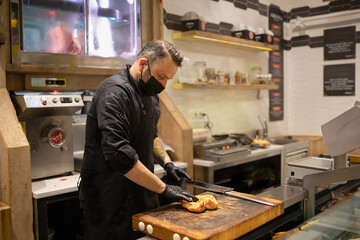 Butcher cuts up fresh farm meat carcass in his store