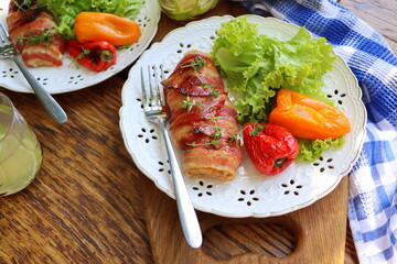 Dinner background. Grilled chicken breast wrapped in bacon served with salad on wooden rustic table . Top view