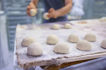 Baker makes bread and buns for baking it