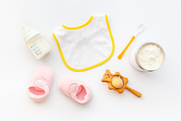 Baby milk in bottle with toy and powdered milk