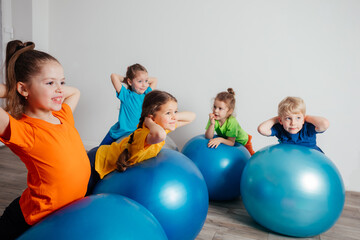 Kids doing physical exercises on large fitballs