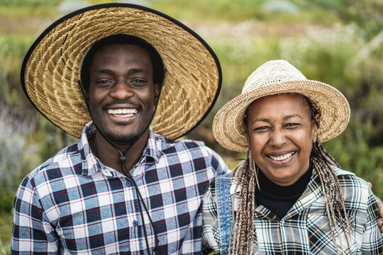 African american farmers smiling on camera during harvest period - Family farm lifestyle concept - Focus on faces