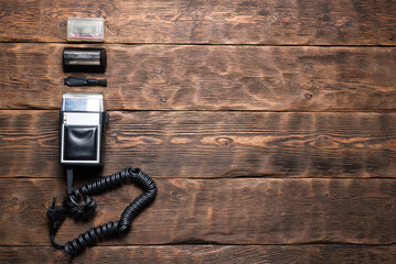 Retro style electric razor on the wooden desk table flat lay background with copy space.