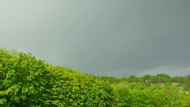 Double rainbow over a wooded hill with gardens