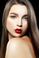 Fototapeta na wymiar Portrait of a beautiful girl in studio with make-up, red lipstick and healthy skin. Black background