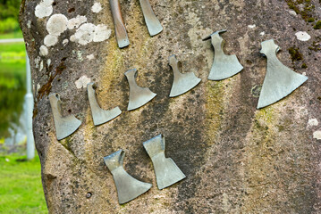 A huge granite stone with axes attached to it. Monument attraction in Estonia, Juri