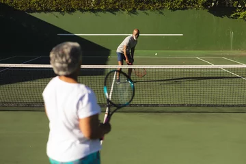 Poster Senior african american couple playing tennis on tennis court © WavebreakMediaMicro