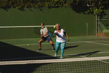 Rolgordijnen Senior african american couple playing tennis on tennis court © WavebreakMediaMicro