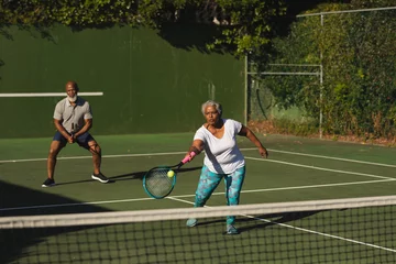 Poster Senior african american couple playing tennis on tennis court © wavebreak3