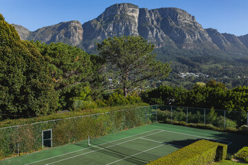 General view of tennis court in stunning countryside on sunny day