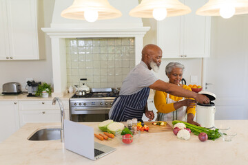 Senior african american couple cooking together in kitchen