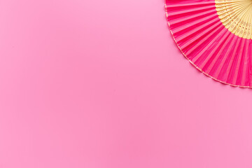 Top view of pink hand fan made of bamboo and paper