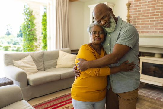 Senior african american couple embracing with eyes closed in living room