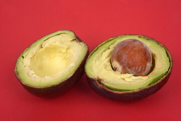 Avocat coupé en deux en gros plan sur fond rouge