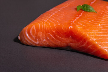 Fresh raw salmon or trout sea fish fillet on black stone background