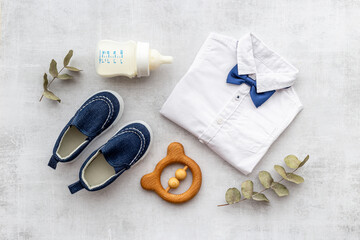 Flat lay of baby boy bodysuit with malk bottle. Baby background