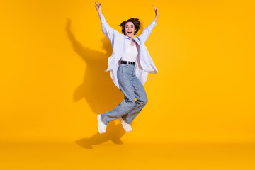 Full length body size photo of funny female student jumping up carefree childish isolated on bright yellow color background