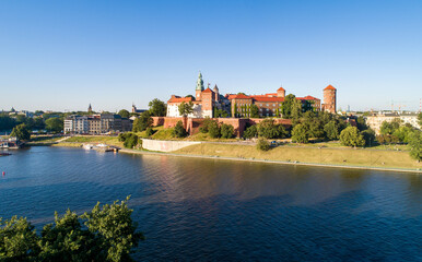 Krakow, Poland. Aerial panorama at sunset with Royal Wawel castle and cathedral. Vistula river bank, trees, park, promenade and walking people