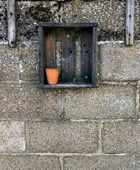 Old wooden box with empty terracotta pot on old block wall