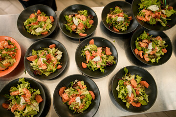top view of bowls of tasty salmon salad with arugula and other greens