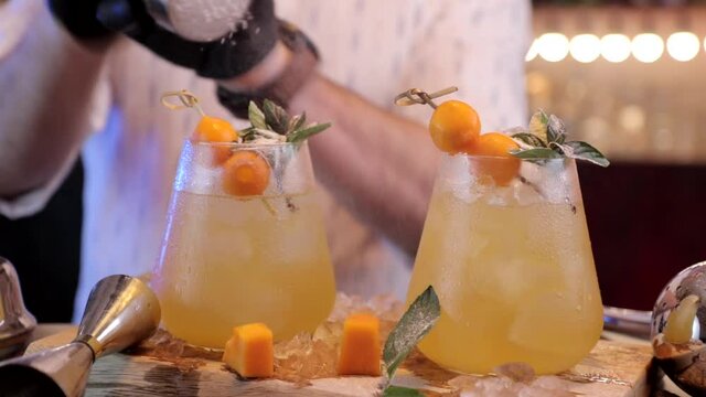 bartender sprinkle with sugar powder  two cocktails
