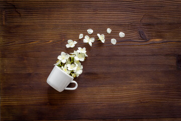 Jasmine flowers flying into a cup. Herbal tea concept