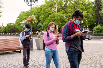 People in masks stand queue keeping social distance