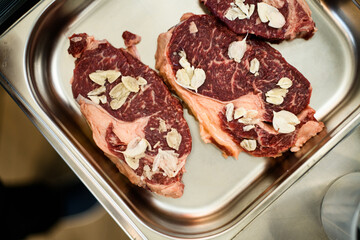 Top view of raw meat steak on a steel baking sheet
