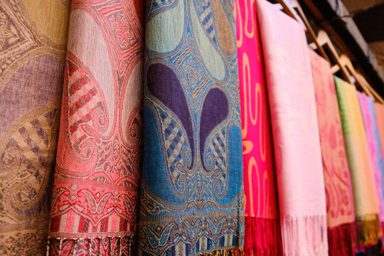 Colorful traditional middle eastern shawls hanging at bazaar. Multi-colored headscarfs