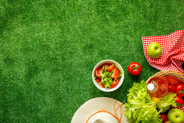 Top view of picnic basket with red tablecloth and fresh summer food