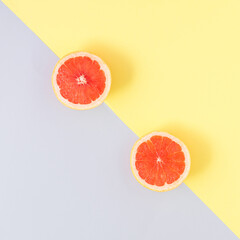 Bright colorfull grapefruit on yellow and grey background. Minimal tropical fruit concept