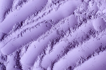 Purple clay powder (alginate face mask, body wrap, make-up eyeshadow) texture close up, selective focus. Abstract lavender background with brush storkes.