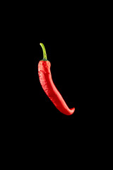 Isolated red pepper. Red hot chili paprika or spicy chile cayenne pepper isolated on black background. Ingredient for fresh spice mexican food.