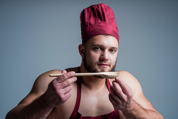 handsome bodybuilder wear cook apron while tasting healthy food, calorie