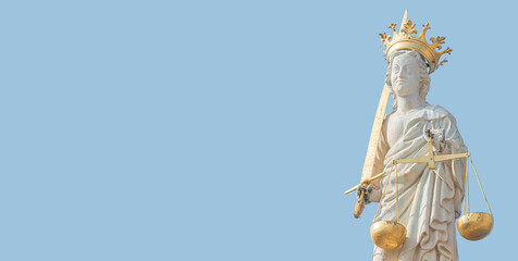 Banner with ancient statue of goddess Justice with sword and scale isolated at the roof top decoration of Doge's Palace in Venice, Italy, summer time, blue sky background, closeup