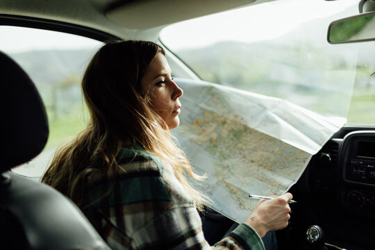 Driver with map in car during trip